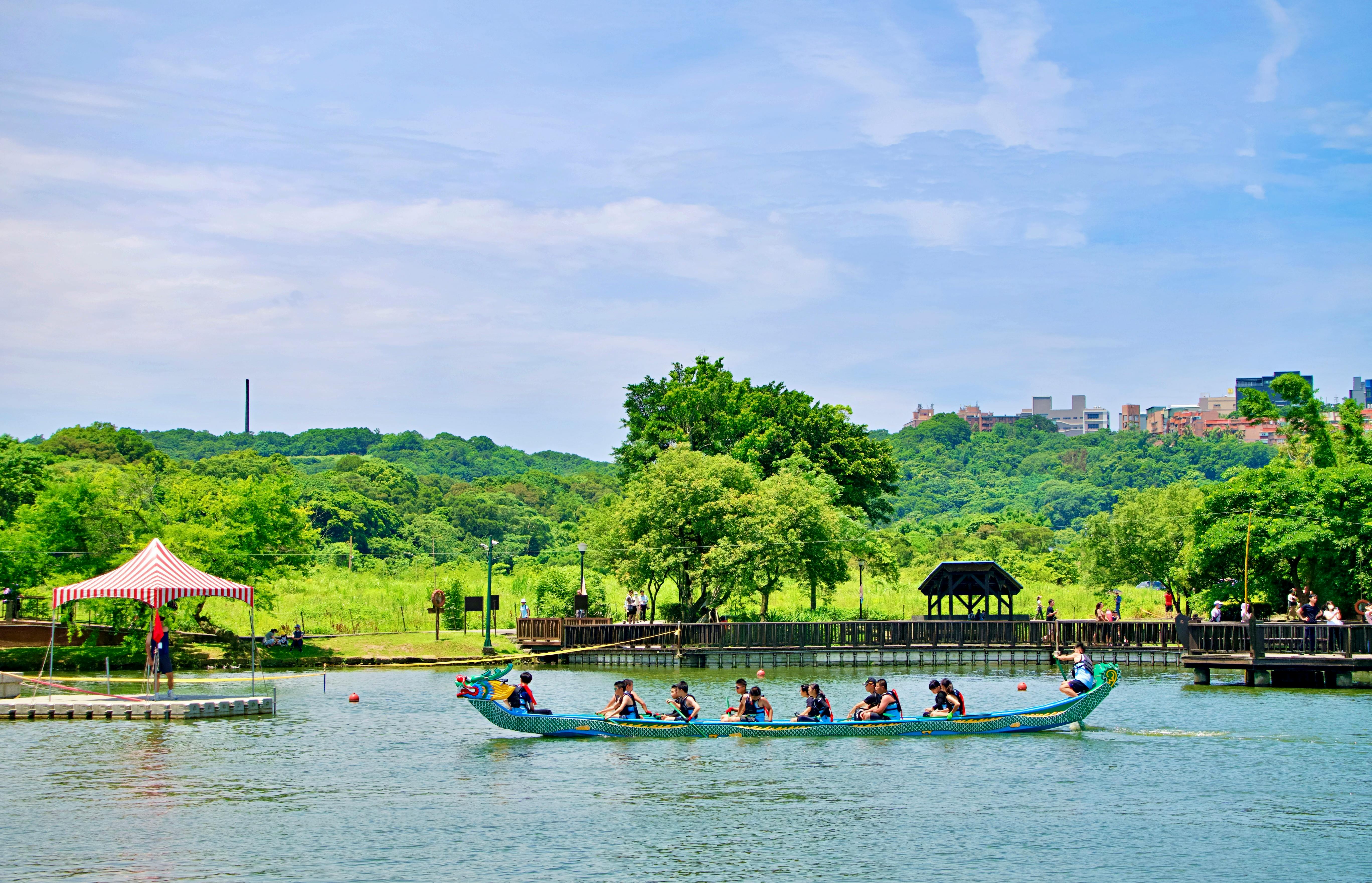 Vibrant dragon boat racing event in lush Taiwan park under a bright blue sky