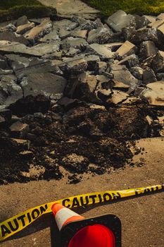 Image of a construction zone with rubble, caution tape, and a traffic cone in Alberta, Canada.