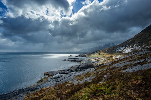 Stunning view of the rugged coastline and moody skies in Lofoten, Norway, showcasing nature's raw beauty.