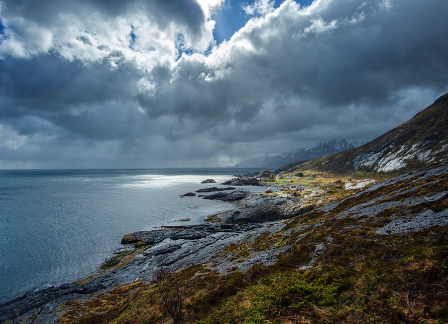 Stunning view of the rugged coastline and moody skies in Lofoten, Norway, showcasing nature's raw beauty.