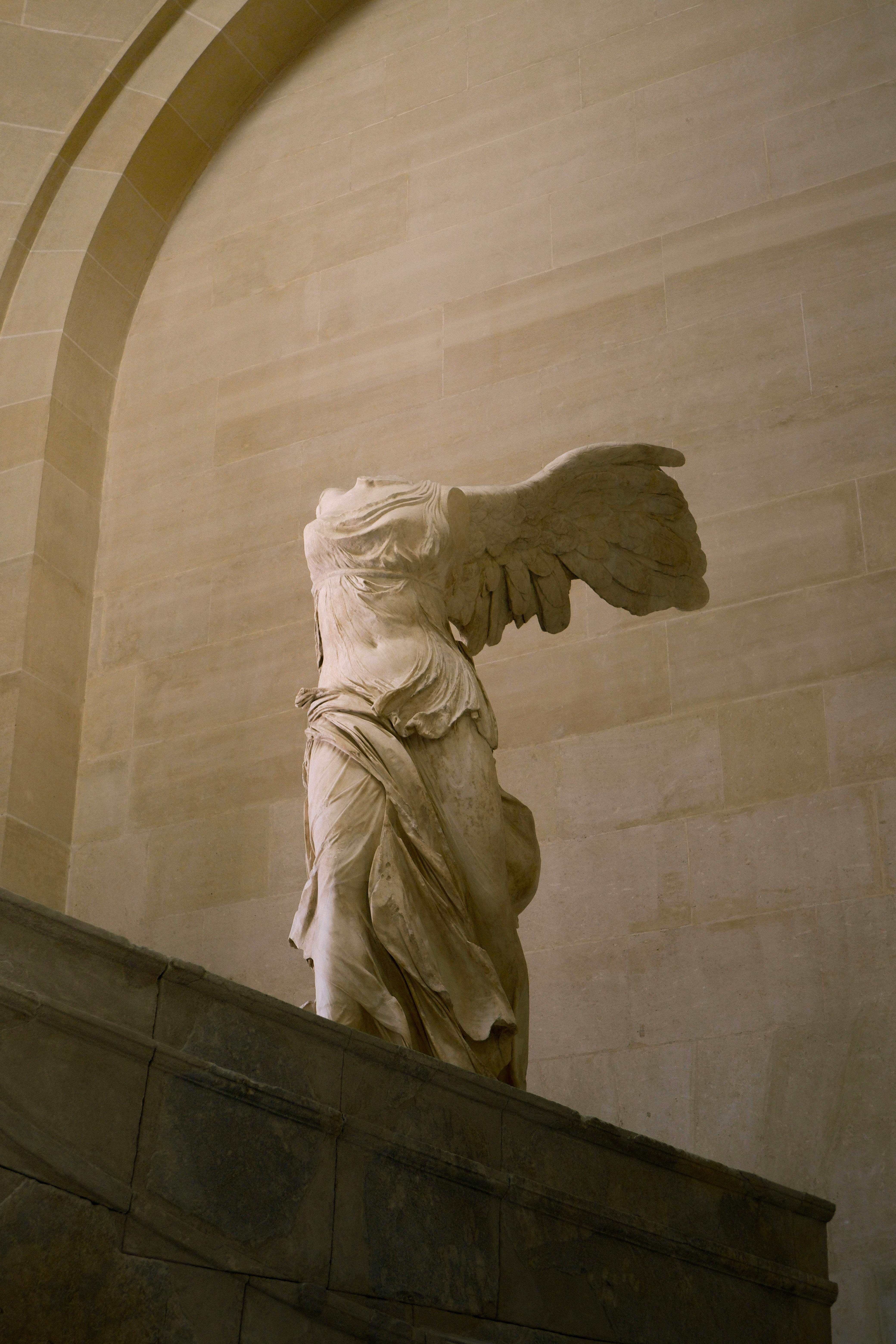 Elegant marble statue at the Louvre, Paris, showcasing classical artistry.