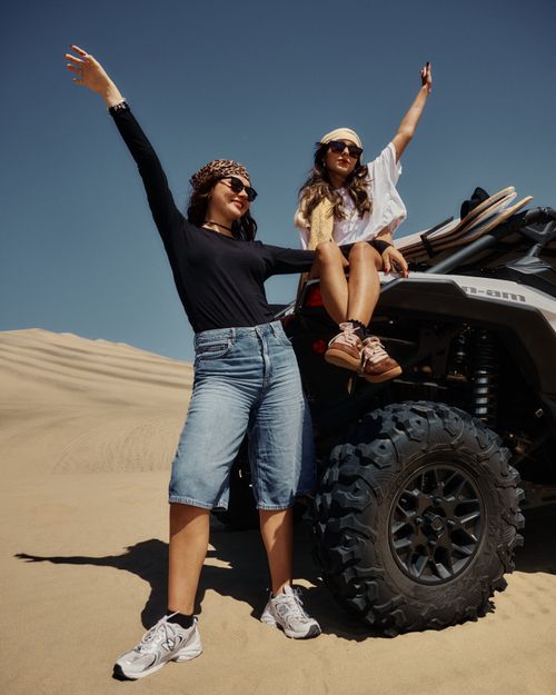 Free Two women celebrate an exciting desert adventure on an ATV under sunny skies. Stock Photo