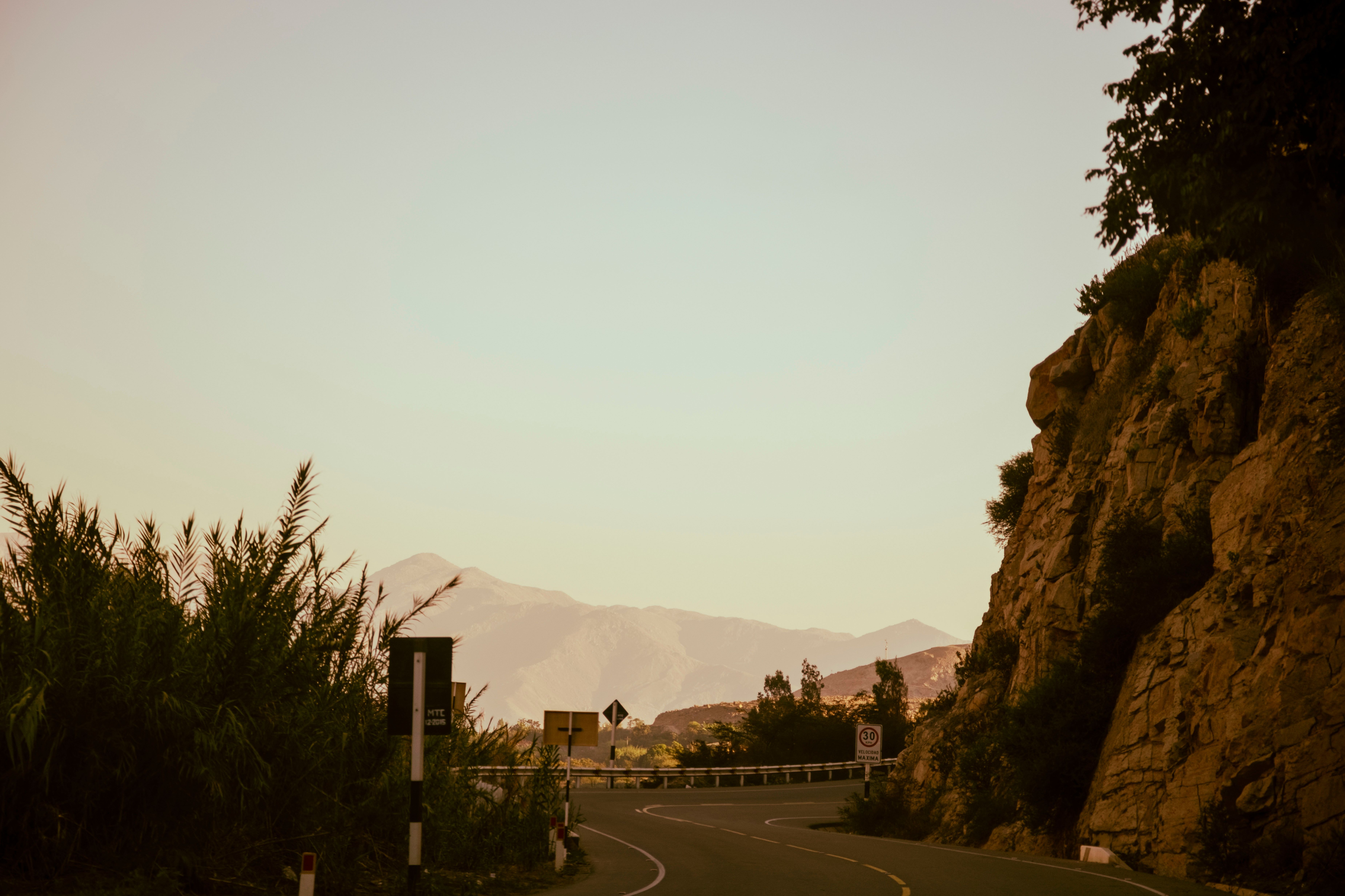 Empty road winding through Aravalli hills at golden hour
