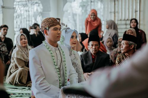 Free Bride and groom at a traditional Indonesian wedding ceremony with family and friends. Stock Photo