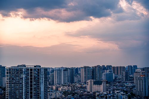 Free A beautiful cityscape featuring tall buildings under a dramatic sky at dusk. Stock Photo