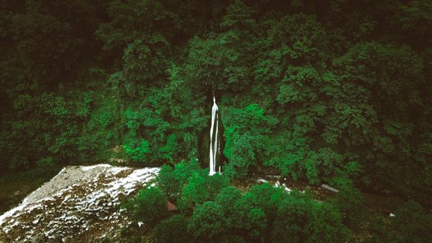 A stunning aerial capture of a waterfall nestled in dense greenery, showcasing the serene beauty of Georgia's natural landscape.