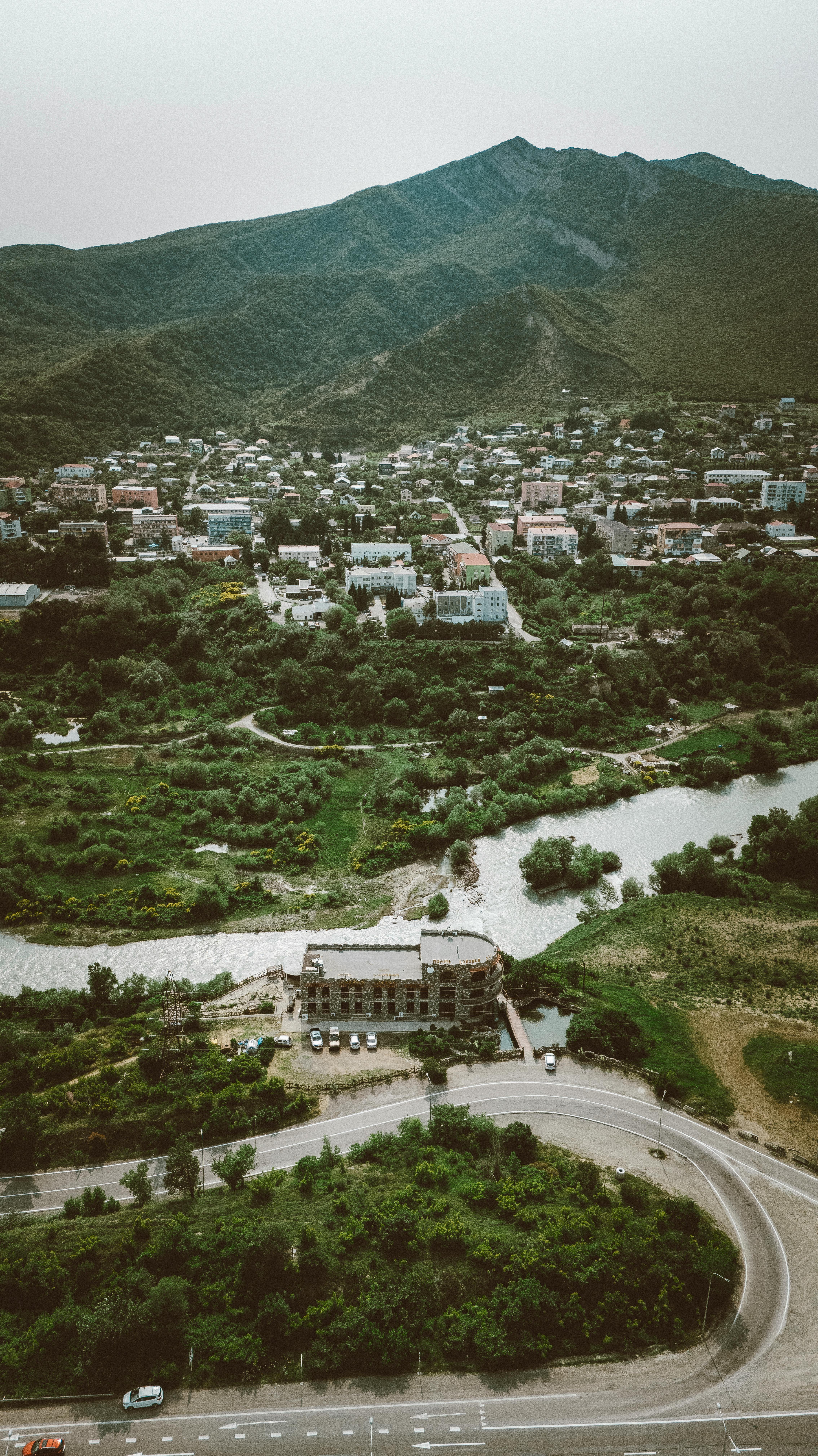 Picturesque aerial view of a town in Georgia amidst lush greenery and mountains.