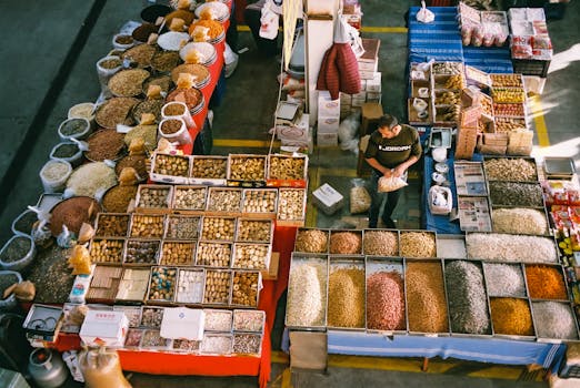 A vibrant overhead view of a market stand filled with spices and nuts, showcasing a diverse range of food products.