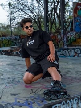 A young man rollerblading in a graffiti-filled skate park in Mexico City, exuding urban style and energy.