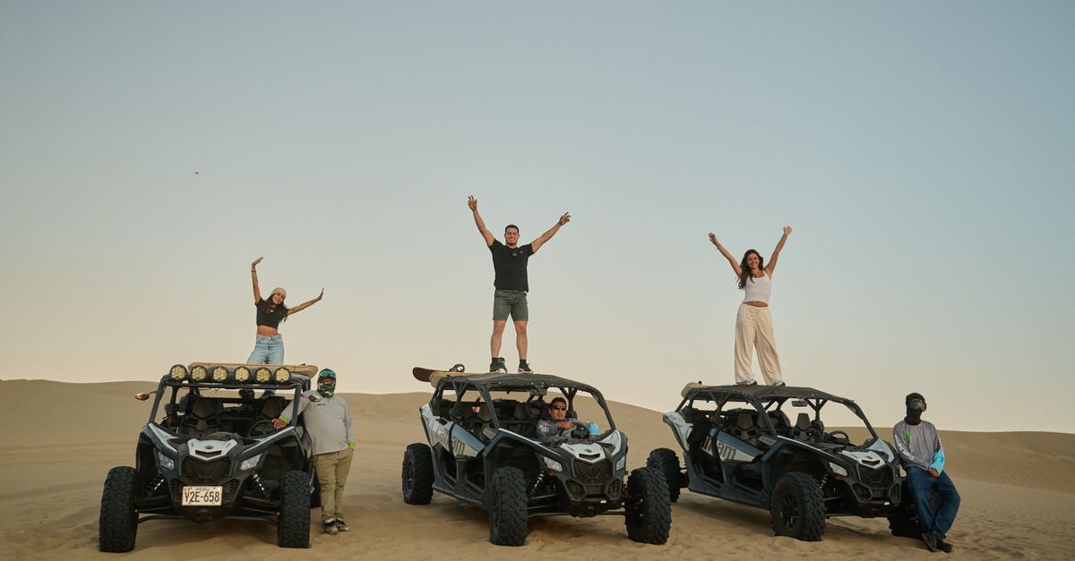 Enthusiastic group enjoying a desert adventure with dune buggies at sunset.