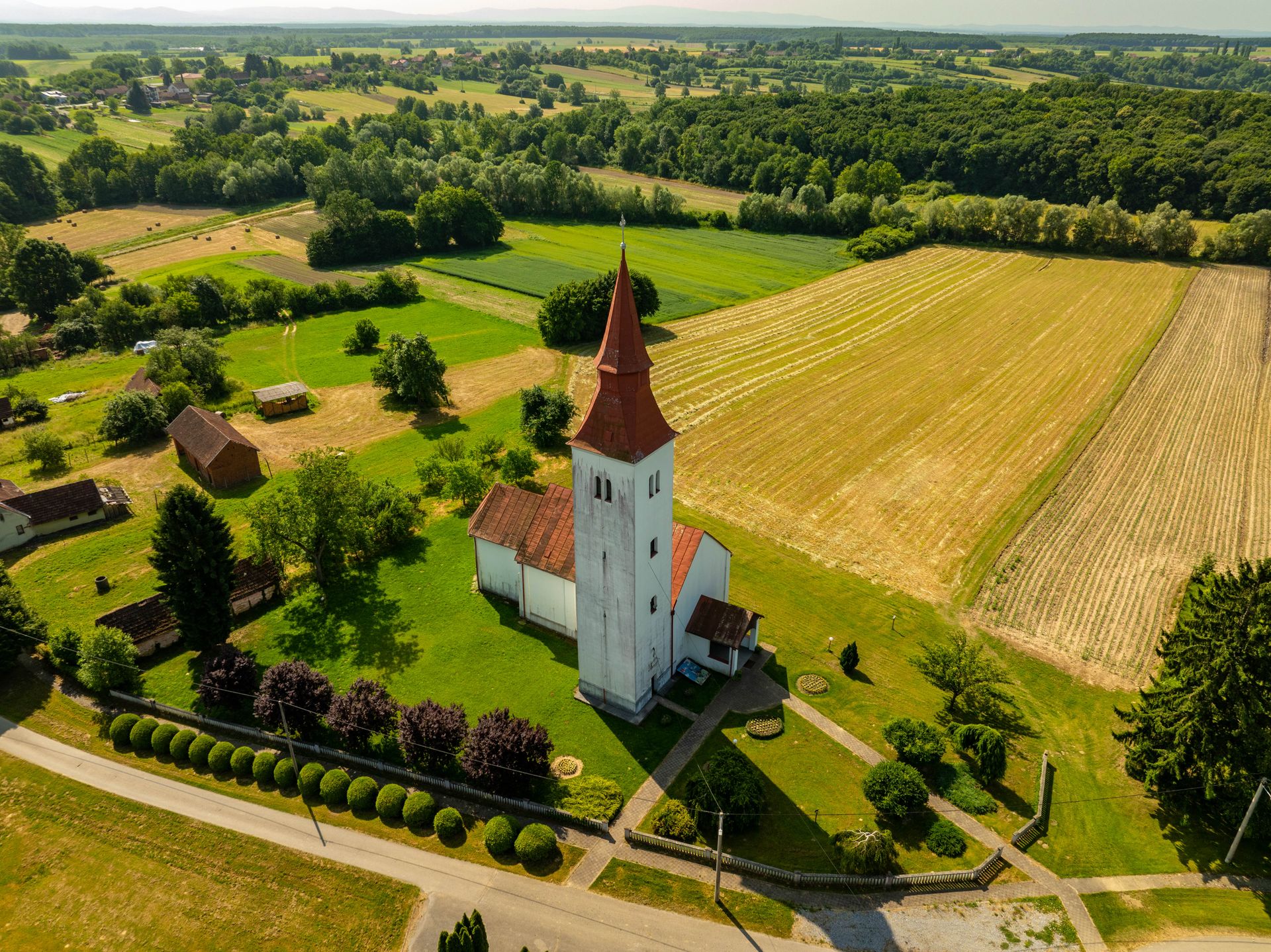 Stunning aerial shot of a rural church and fields in Velika Trnovitica, Croatia.
