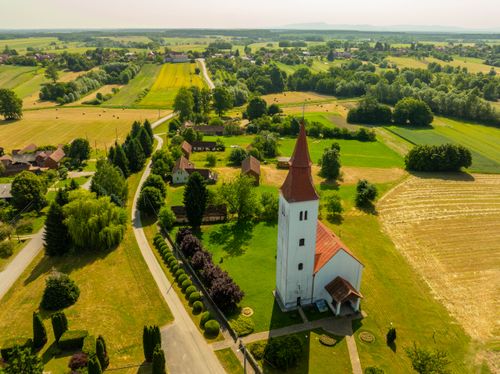 Free Charming aerial shot of a countryside church in Velika Trnovitica, Croatia, surrounded by fields and greenery. Stock Photo