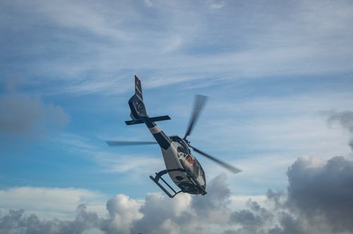 Free A helicopter in flight with a backdrop of a vibrant sky and dramatic clouds. Stock Photo