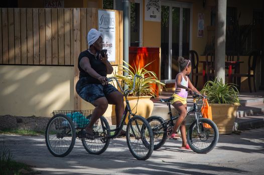 Two people enjoy a leisurely bike ride in a sunny urban setting, highlighting community and leisure.