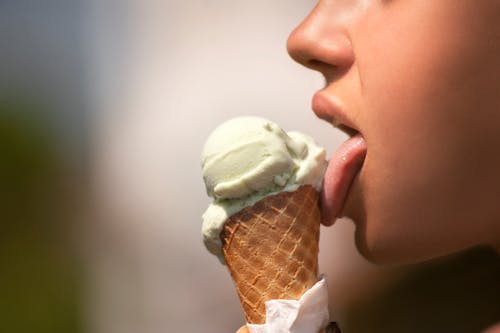 무료 아이스크림을 핥는 여자 스톡 사진