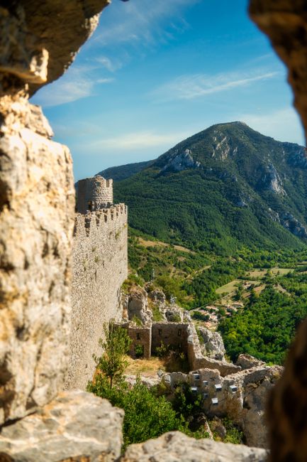 Explore the breathtaking Montségur Castle ruins amidst the Pyrenees mountains in France.
