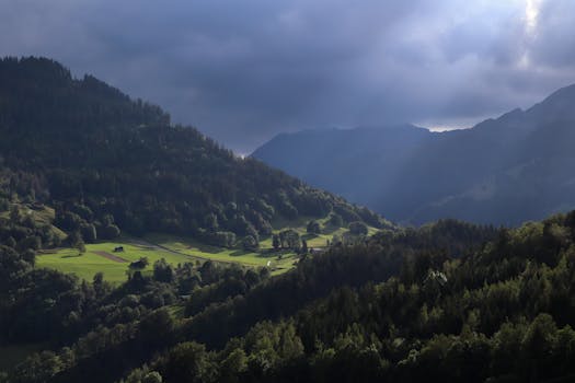 Stunning early morning landscape of valleys and hills near Beaufort, France, with mist and sunlight.