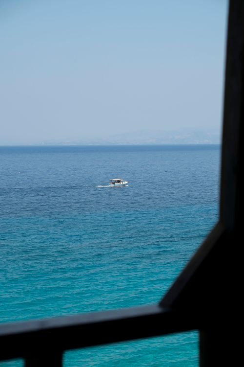 Free A serene scene of a boat sailing on the Aegean Sea near Aydın, Türkiye, with clear blue waters. Stock Photo