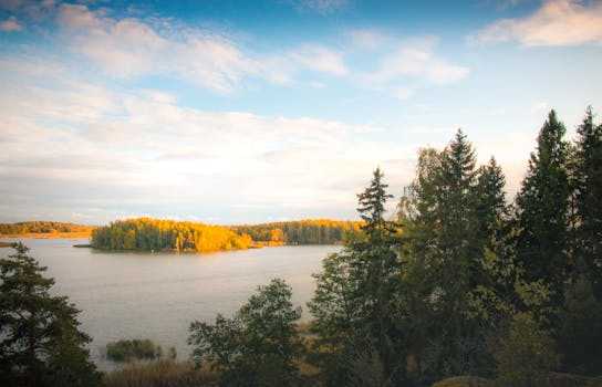 芬兰博尔格诺宁静的秋日景致中，树木色彩斑斓，湖泊平静如镜