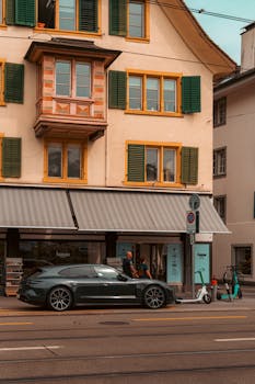 A contemporary car parked on a vibrant Zurich street with traditional architecture.