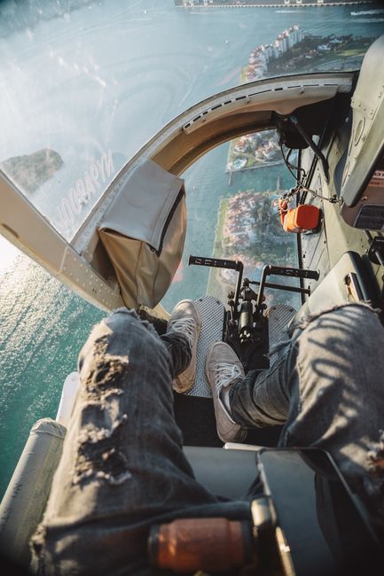 Scenic aerial view from a helicopter flying over the Miami coastline, capturing a vibrant cityscape below.