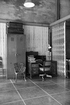 Black and white photo of a vintage industrial office interior with retro furniture.