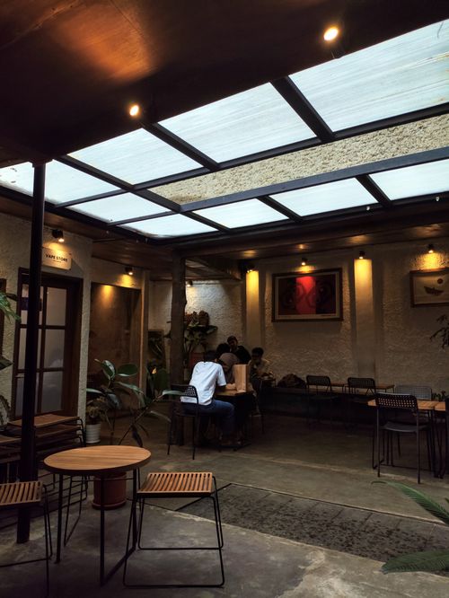 Free A peaceful indoor café with modern decor and natural lighting from a skylight. Stock Photo