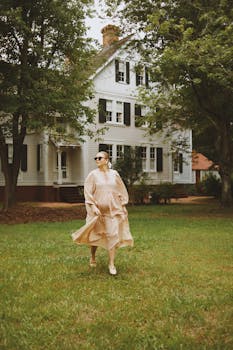 A woman in a flowing dress walks gracefully by a historic home in North Carolina, USA.