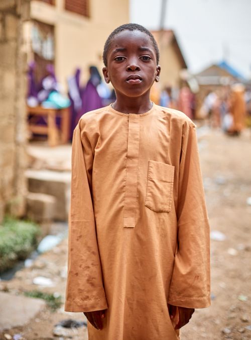 Free A young boy in traditional attire stands outdoors in Kaduna, Nigeria. Stock Photo