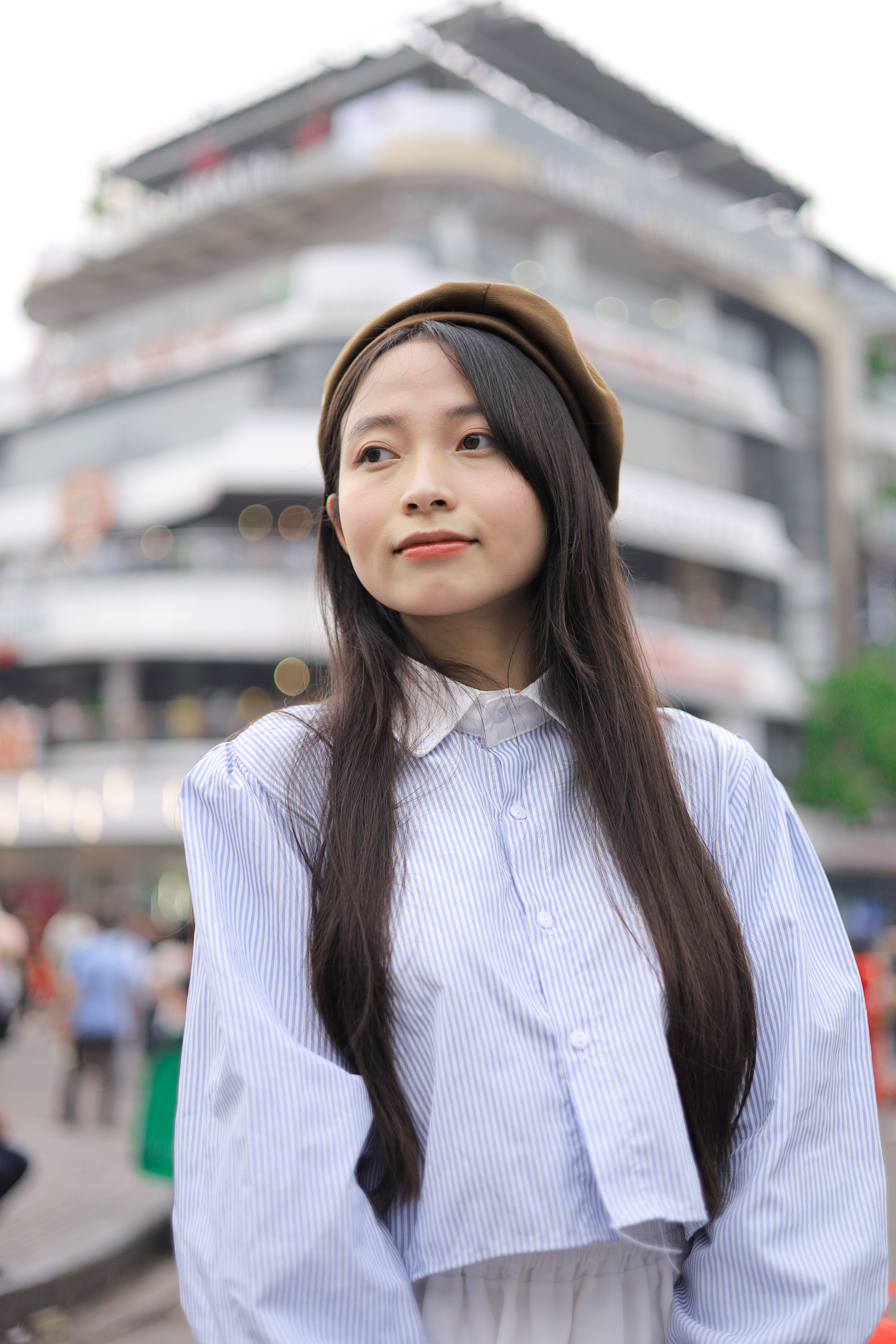 Portrait of a young woman with long hair in an urban area of Hà Nội, Vietnam.