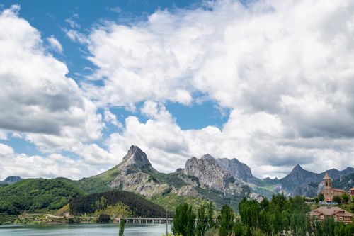 Free Spectacular view of mountains and a church in Riaño, Spain under a dramatic sky. Stock Photo