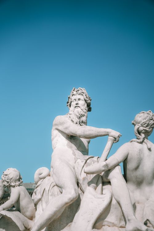 Free Detailed view of marble sculptures at Tuileries Garden in Paris under a clear blue sky. Stock Photo