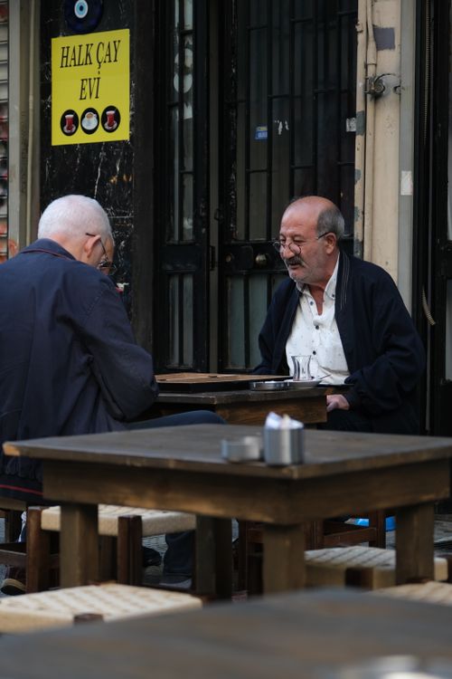 Free Two elderly men enjoy a conversation at an outdoor cafe. Stock Photo