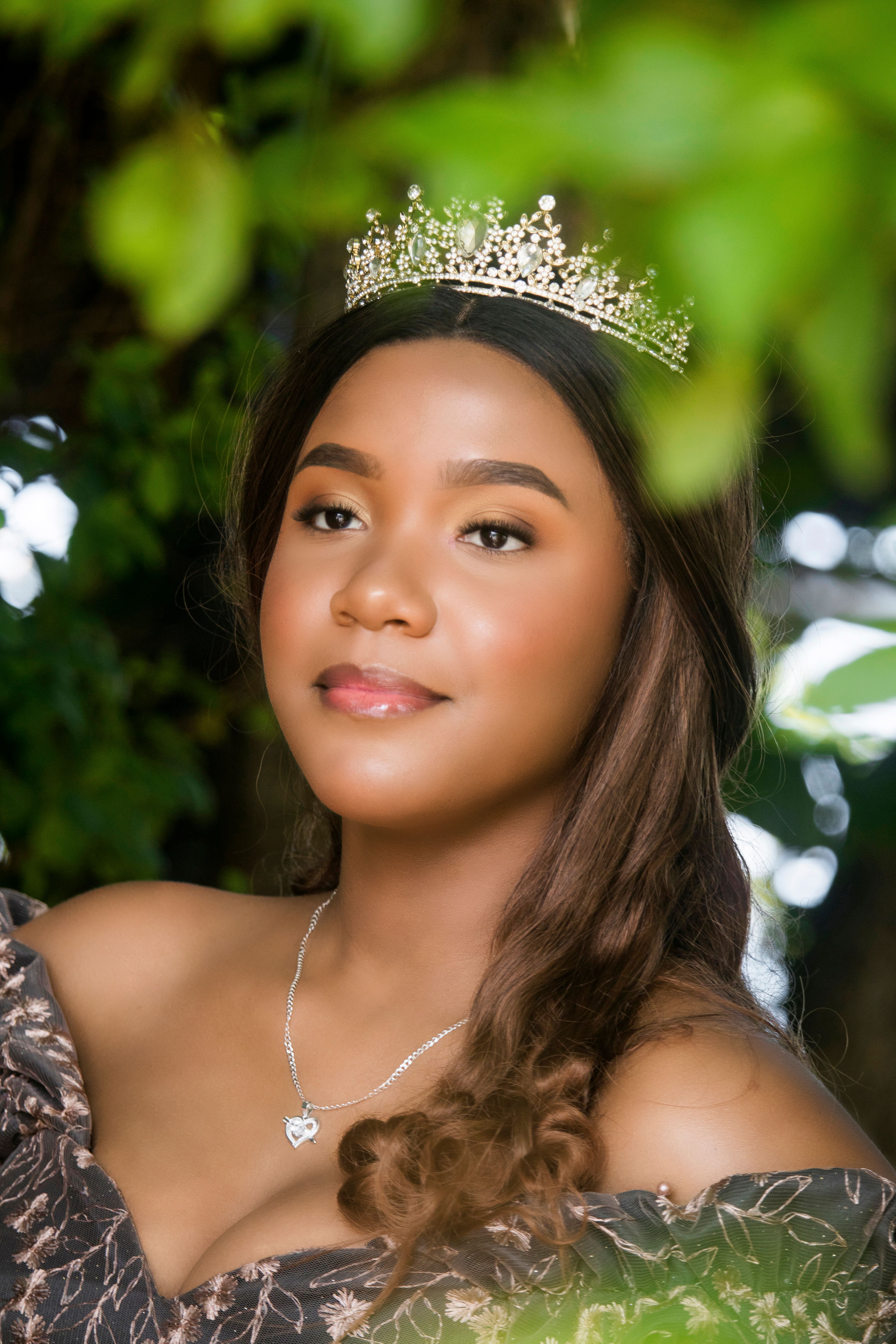 De franc Un preciós retrat de quinceañera que mostra una dona jove amb una corona enmig d'un exuberant jardí verd a Puerto Plata. Foto d'estoc