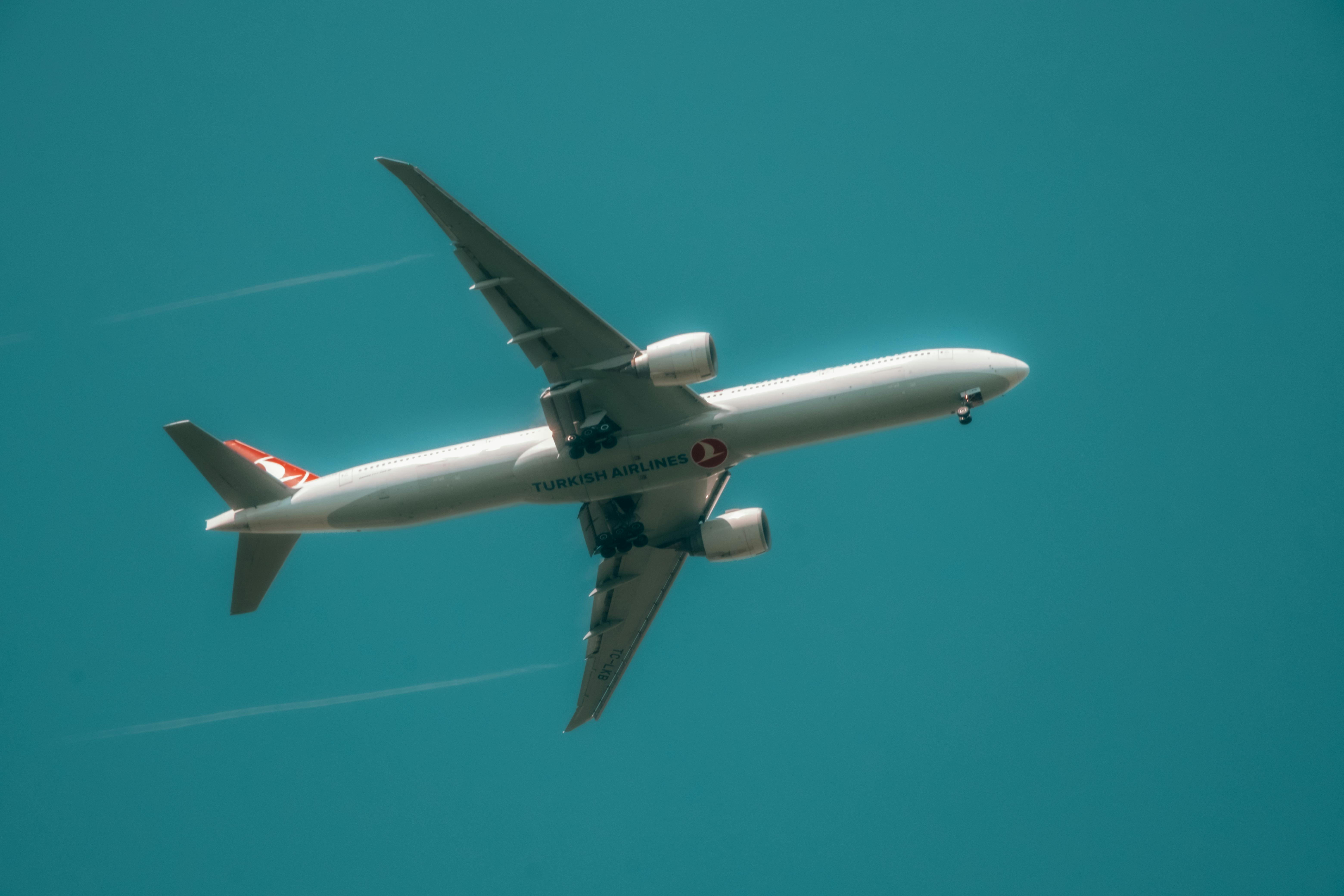 Photo of a Turkish Airlines airplane in flight taken from below with clear skies.