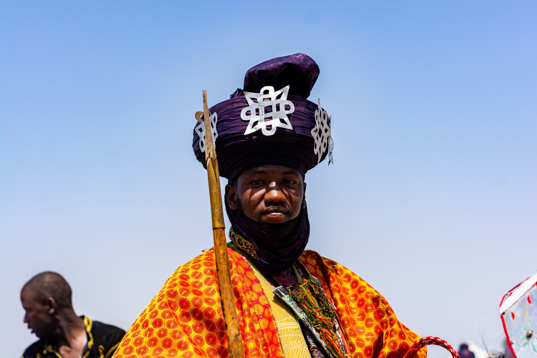 Portrait of a man in vibrant traditional African attire during a cultural festival.