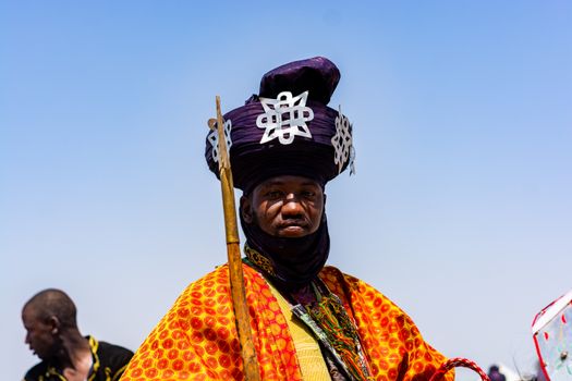 Portrait of a man in vibrant traditional African attire during a cultural festival.