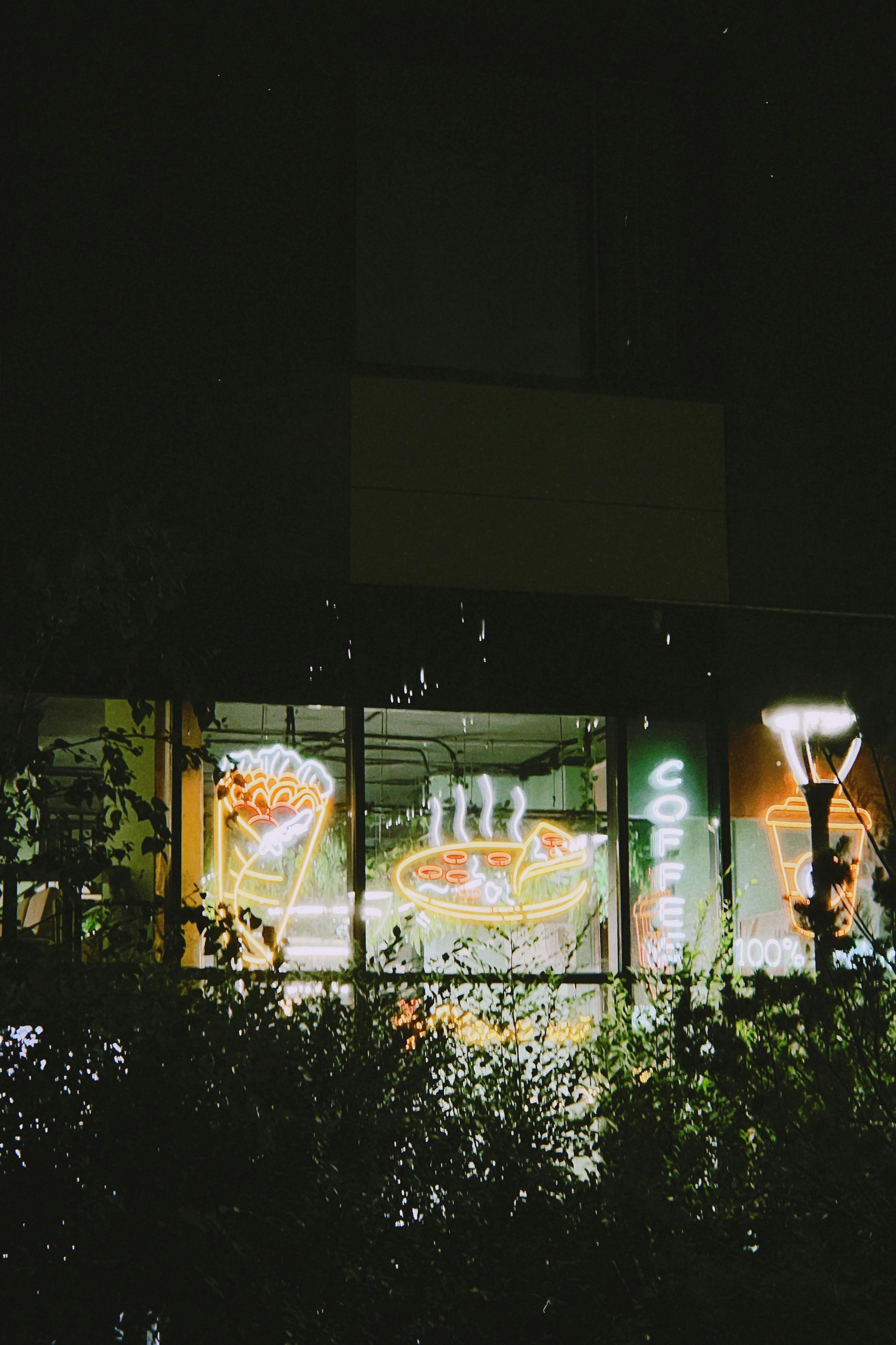 Ücretsiz Astana'da bir kafenin karanlık bir fon üzerinde renkli neon tabelalarla dolu canlı bir gece manzarası. Stok Fotoğraflar