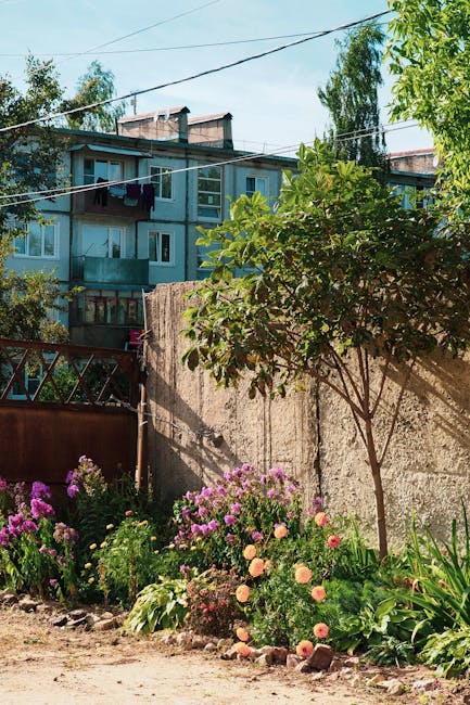 Vibrant garden blooms in front of a Soviet-era apartment block in Kaluga Oblast, Russia.