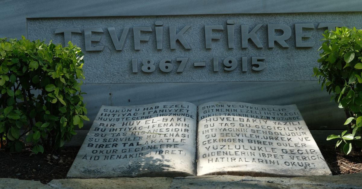 Memorial stone of Tevfik Fikret (1867-1915) surrounded by greenery in a serene garden setting.