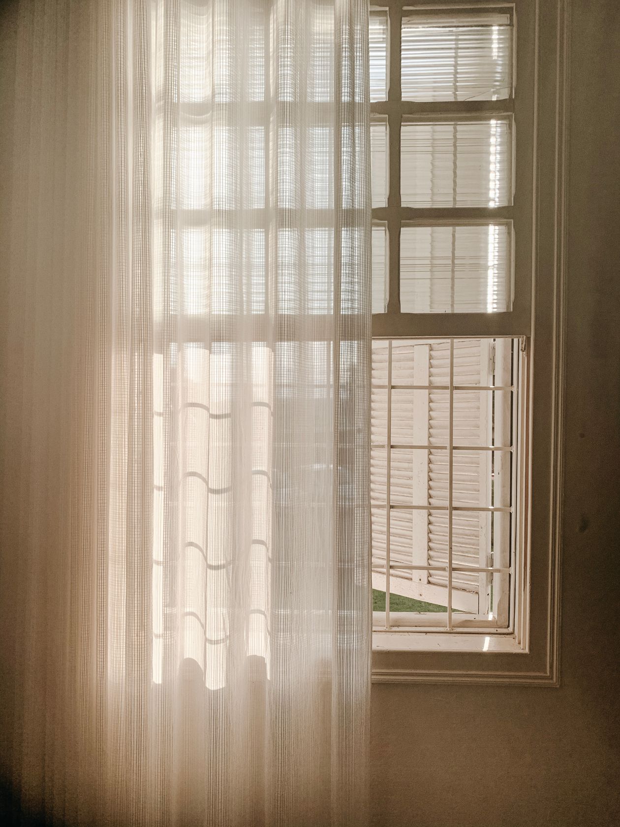 Sheer curtain hanging full-length on a bright window
