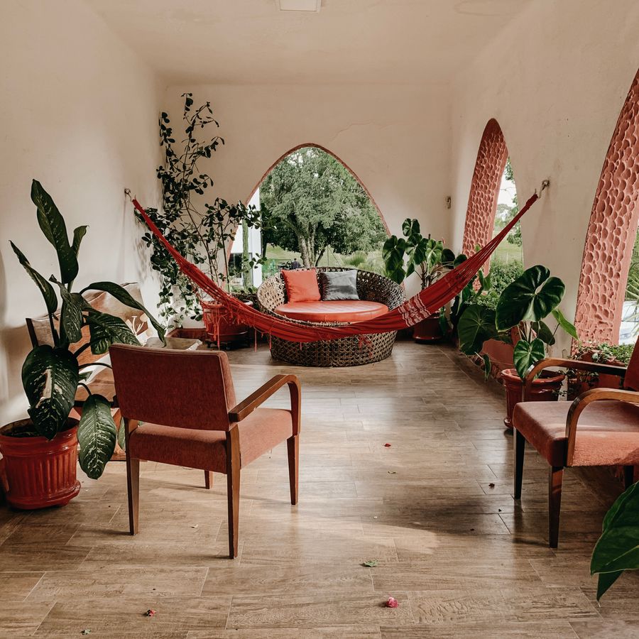 Indoor patio with plants and an arched opening onto a garden — photo by Jonathan Borba on Pexels