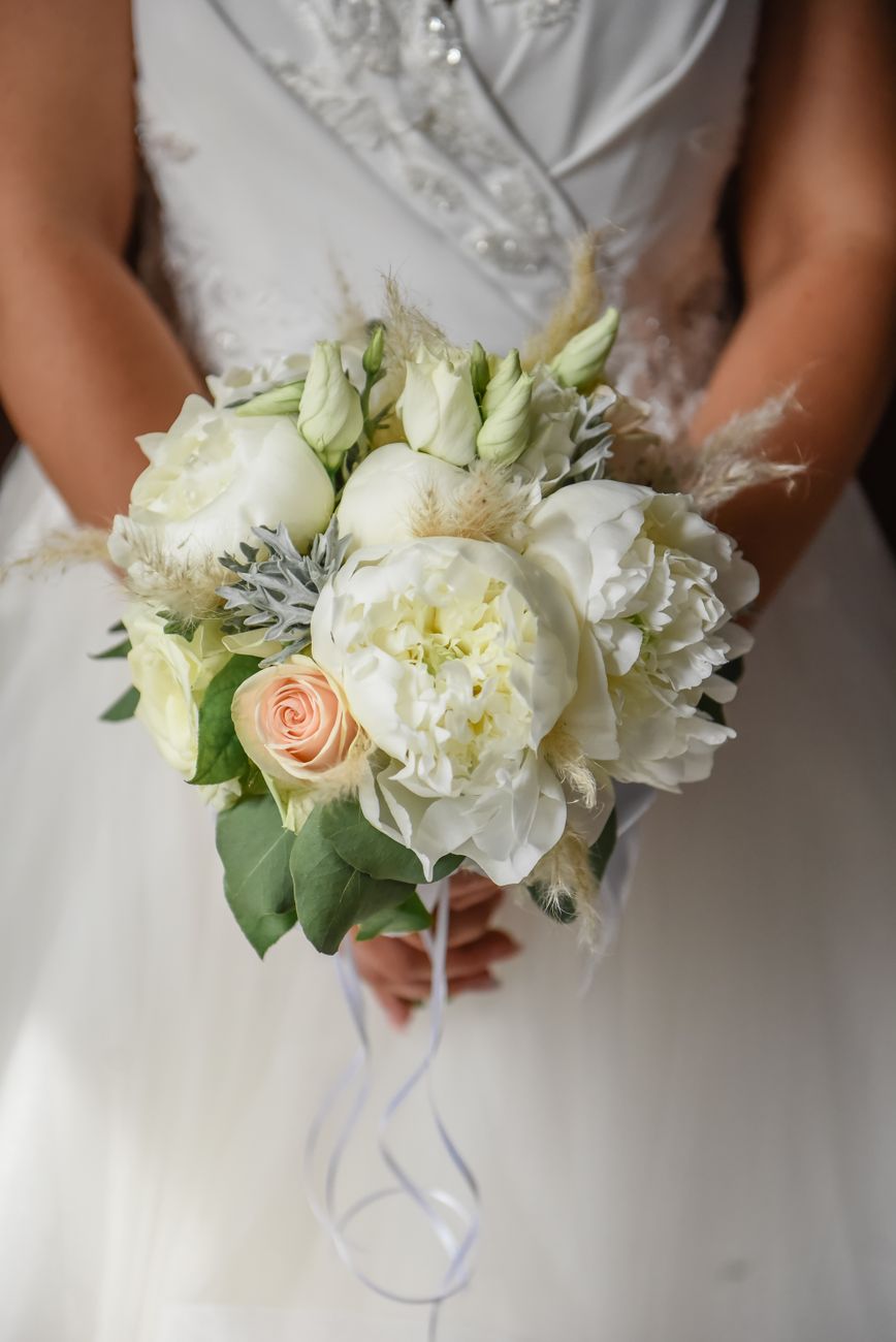 Beautiful bridal bouquet featuring white peonies and roses, perfect for wedding elegance.