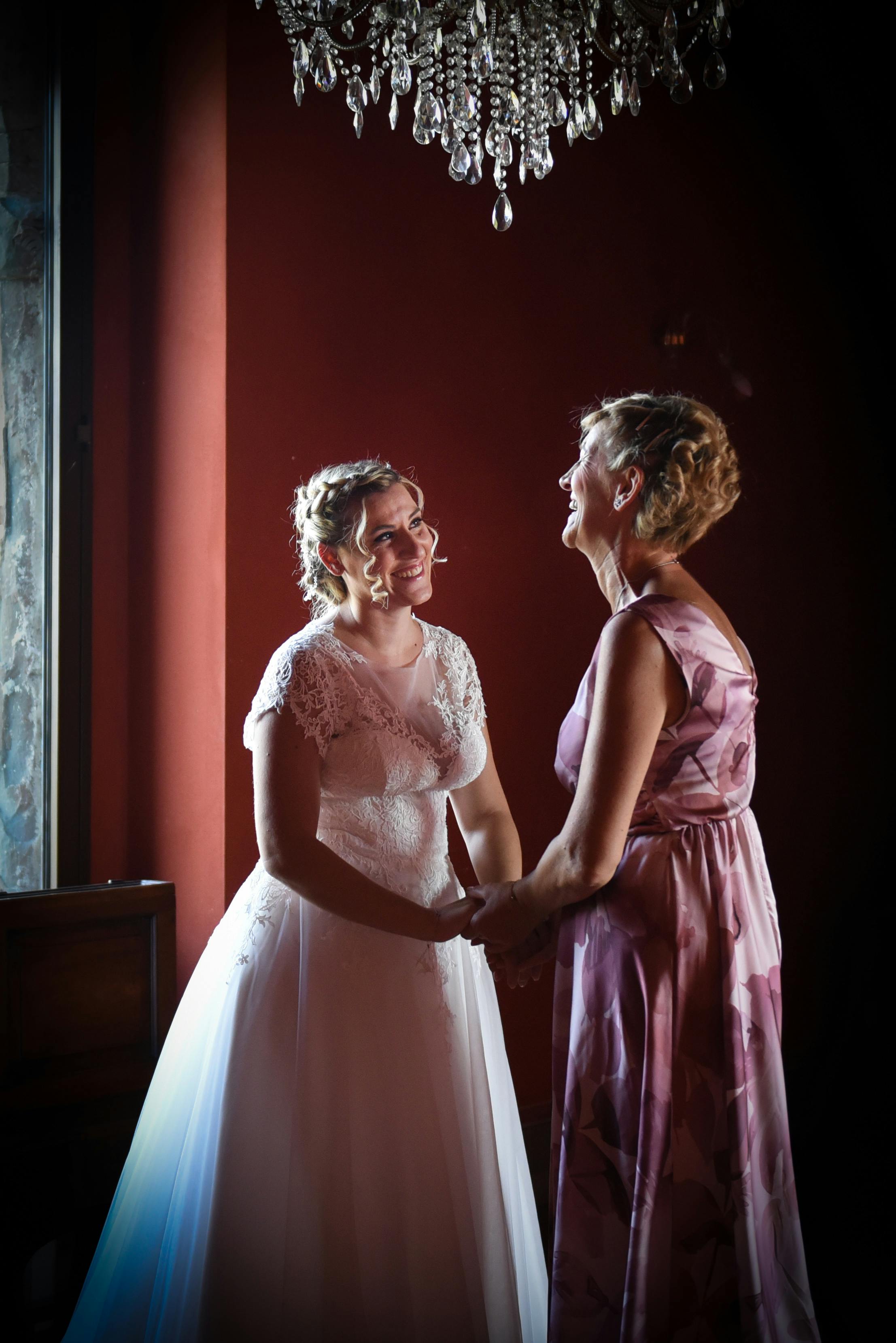 Bride shares a joyful moment with a loved one in Marne, Italy.