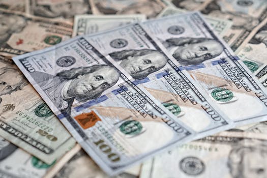 A detailed close-up of multiple U.S. dollar banknotes arranged in a scattered layout.