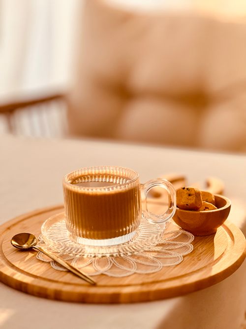 Free A warm and inviting scene of a coffee cup on a tray with cookies, capturing a cozy indoor moment. Stock Photo