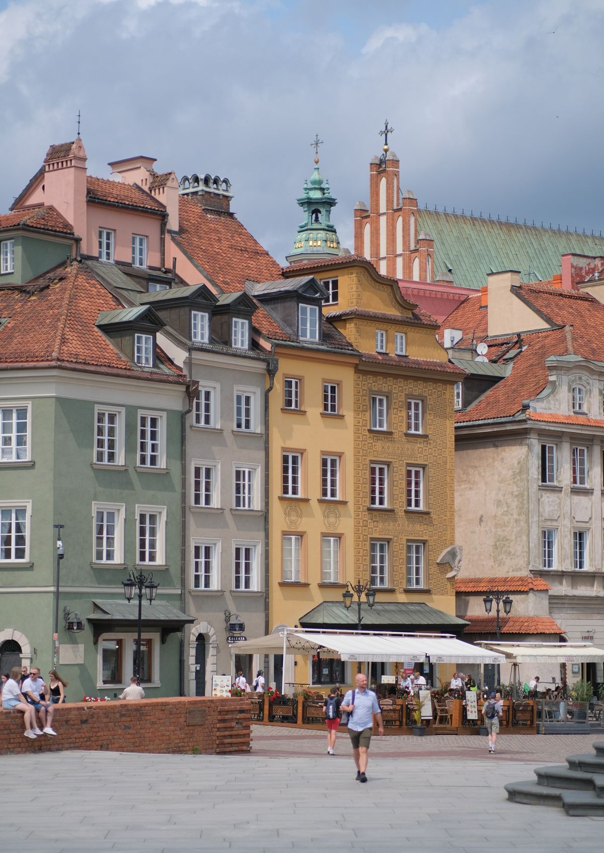 As coloridas casas reconstruidas e as torres de igreja da cidade velha de Varsovia