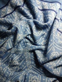 Close-up of blue and white fabric with intricate patterns for textile design.