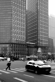 Black and white city scene with skyscrapers and motion blur traffic.