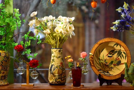 Beautiful floral arrangement with colorful vases and patterned plate. Perfect for interior decor inspiration.